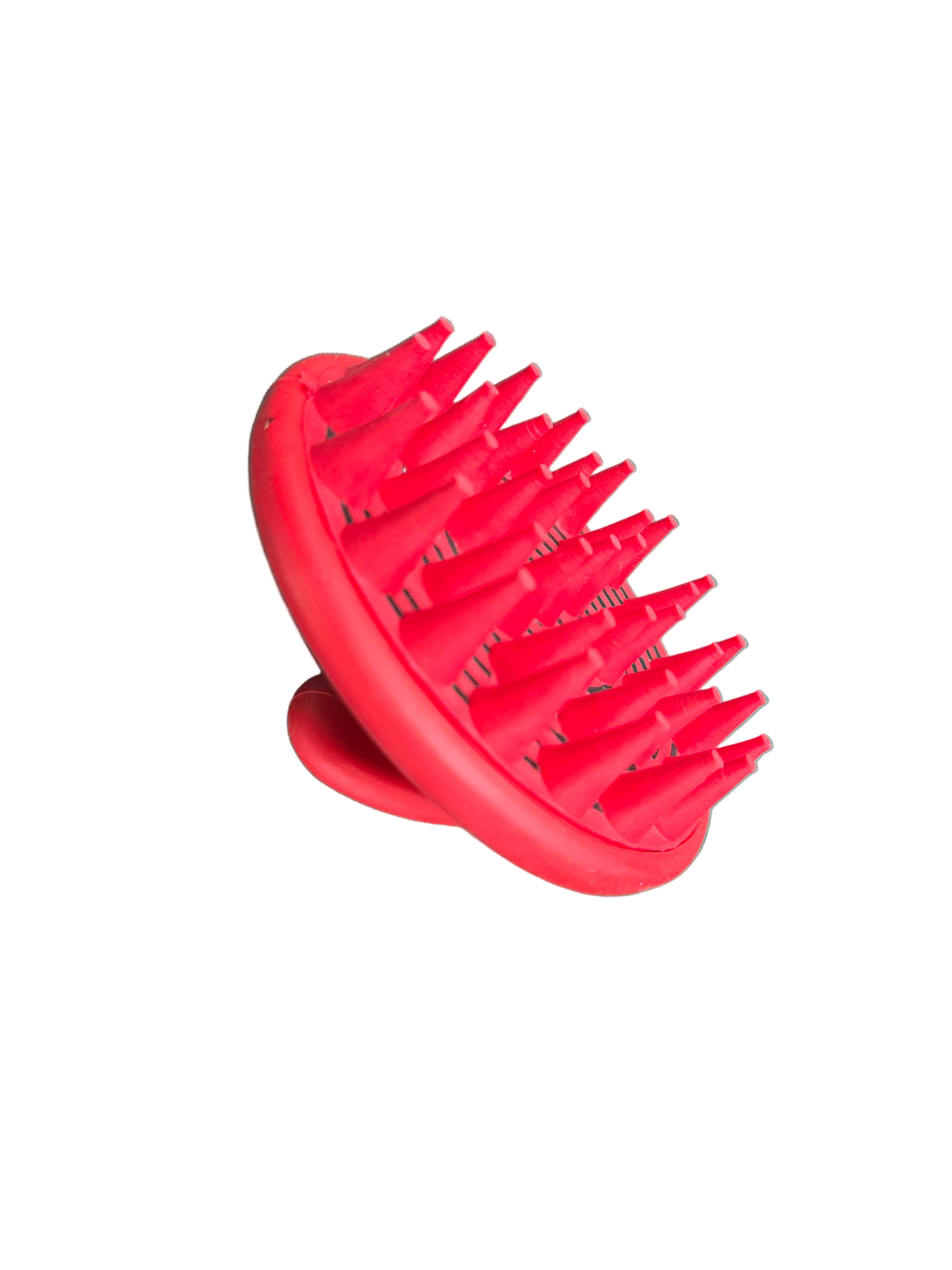 Red grooming tool with prongs on a green surface